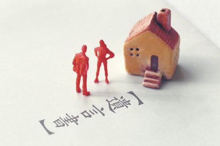 A photo showing inheritance troubles using miniature dolls, a house, and textの写真素材