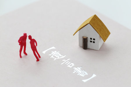 A photo showing inheritance troubles using miniature dolls, a house, and textの写真素材