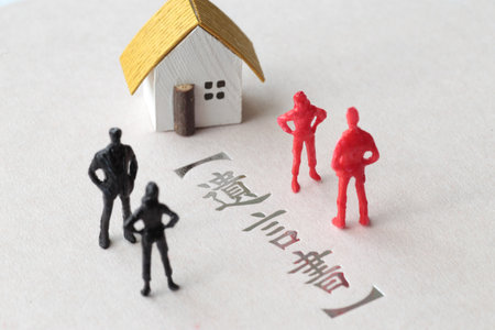 A photo showing inheritance troubles using miniature dolls, a house, and textの写真素材