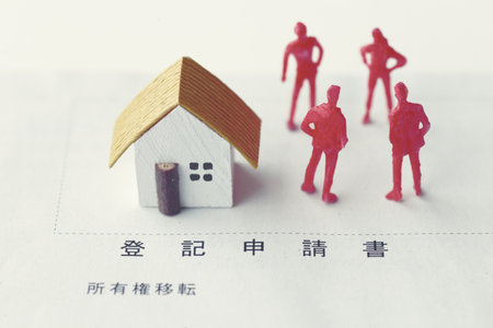 A photo showing inheritance troubles using miniature dolls, a house, and textの写真素材