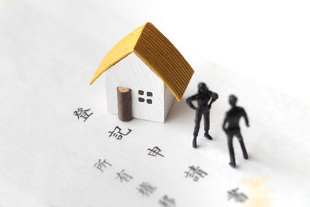 A photo showing inheritance troubles using miniature dolls, a house, and textの写真素材