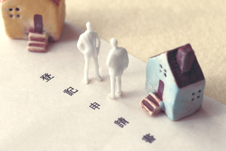 A photo showing inheritance troubles using miniature dolls, a house, and textの写真素材