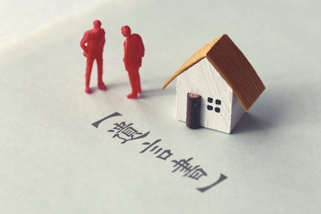 A photo showing inheritance troubles using miniature dolls, a house, and textの写真素材