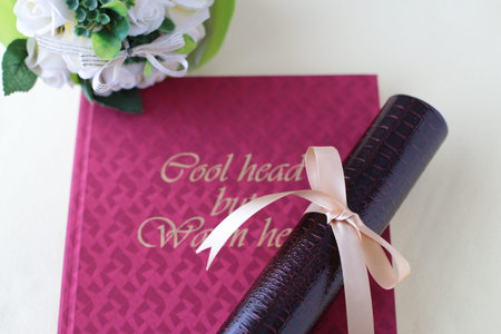 Graduation certificate, graduation album and cherry blossom petalsの写真素材