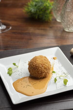 Arancini made with risotto and stuffed mozzarella on sauceの写真素材