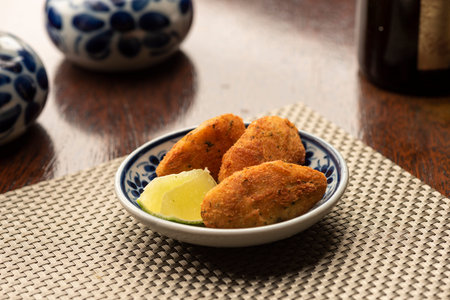 cod fish fried balls snack starter portuguese traditional bolinho de bacalhau on wooden table mat...