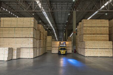 wood pallet forklift driving at a factory floor inside a shedの写真素材