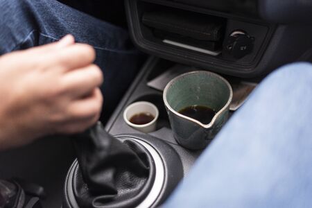 coffee cups brewed inside a car on dashboard with beautiful light and depth of fieldの写真素材