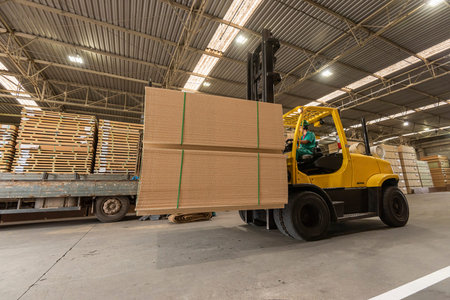wood pallet forklift driving at a factory floor inside a shed