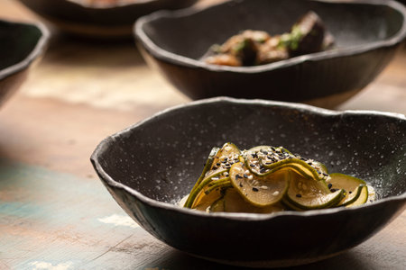 asian fermented kimchi fermented food pickles on a black bowl and other ingredients on background