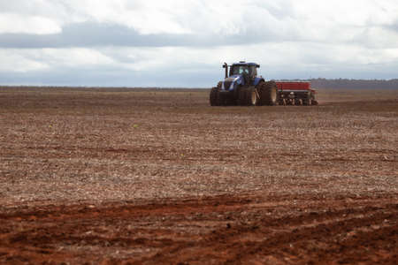 plowing machine harvesting on a sunny day and cloudsの写真素材
