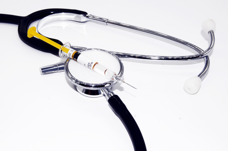 Medicine, tablets, stethoscope, and syringe on white backgroundの写真素材