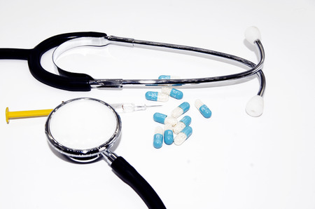 Medicine, tablets, stethoscope, and syringe on white backgroundの写真素材
