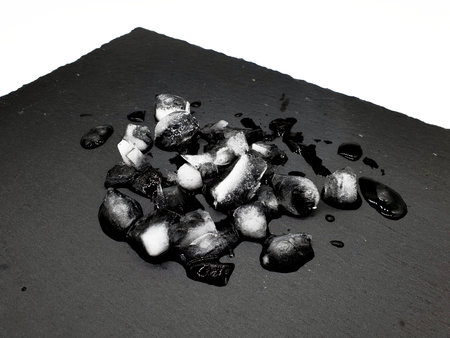 Ice and water on black slate background