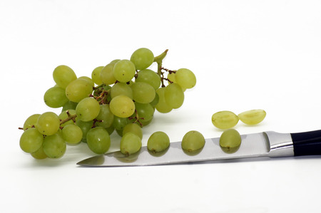 Grapes on the knife isolated on white backgroundの写真素材