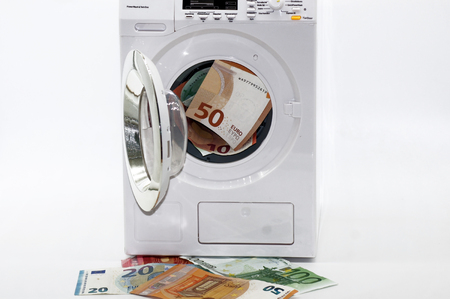 Illegal money laundering black money released on white backgroundの写真素材