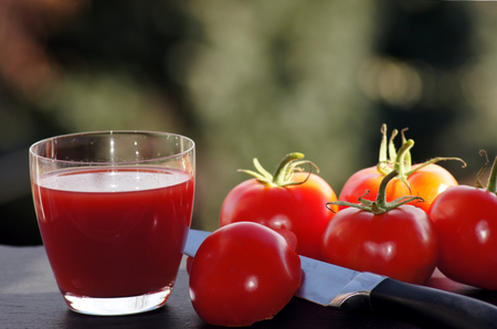 Red tomatoes with a glass of tomato juiceの写真素材