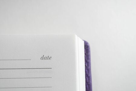 Violet diary. In the corner is the inscription Date. On white background.の写真素材