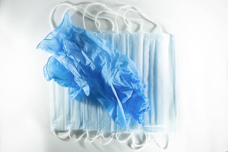 disposable blue medical gloves and medical masks on a white background.