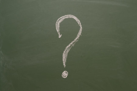 Handwritten chalk inscription question mark on green boardの写真素材