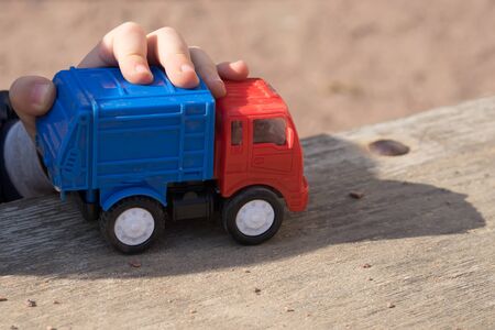 Walks for children in the fresh air. Part of the image of a small child who sits and plays with a trash car.の写真素材