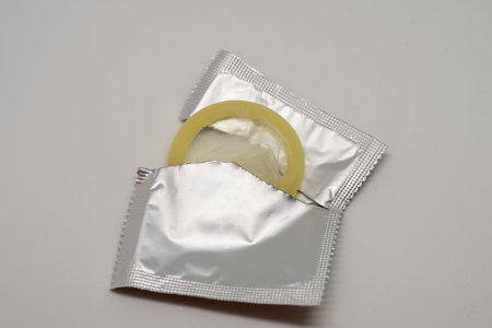 Yellow open condom on a white backgroundの写真素材