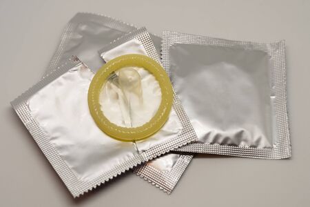 Yellow open condoms on a white backgroundの写真素材