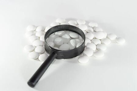 white pills through a magnifier. On white backgroundの写真素材