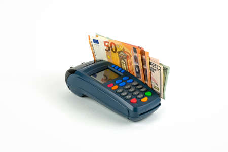 Dark blue payment terminal with multi-colored pins on a white background. Dollar and euro bills. Front view.の写真素材
