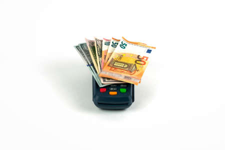 Dark blue payment terminal with multi-colored pins on a white background. Dollar and euro bills. Front viewの写真素材
