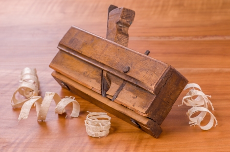 old molding plane with shavings on a cherry wood boardの写真素材