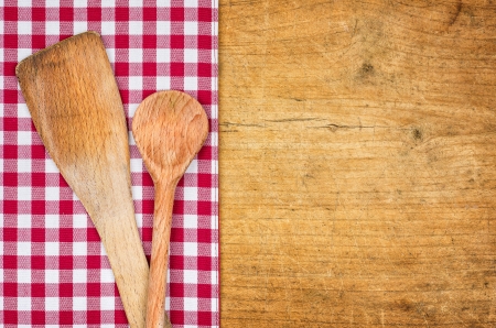 Rustic wooden background with checkered tablecloth and wooden spoonの写真素材