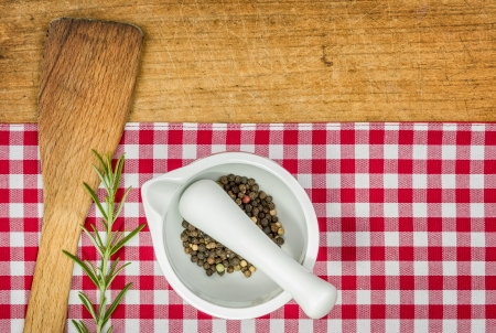 Wooden spoon and mortar on a wooden board with checked tableclothの写真素材