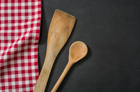 Wooden spoon on a blackboard with a red checkered tableclothの写真素材