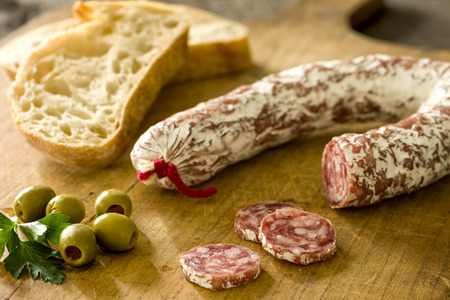Salami with baguette and green olivesの写真素材