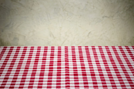 Background with checkered tablecloth and a rustic wall
