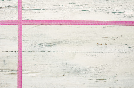 Pink ribbons on a white wooden backgroundの写真素材