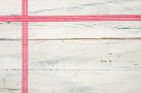 Red ribbons on a white wooden backgroundの写真素材