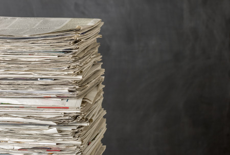 A pile of newspapers on a dark backgroundの写真素材