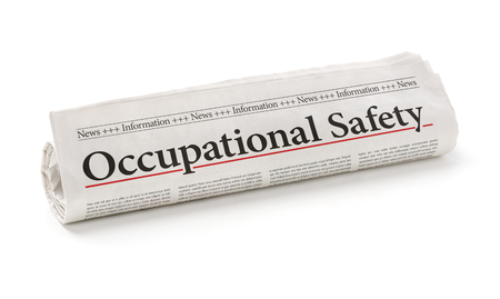Rolled newspaper with the headline Occupational Safetyの写真素材