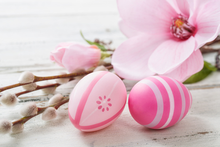 Pink easter eggs on a wooden background with a magnoliaの写真素材