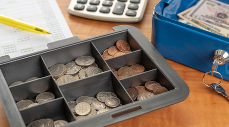 A cash box with coins and billsの写真素材