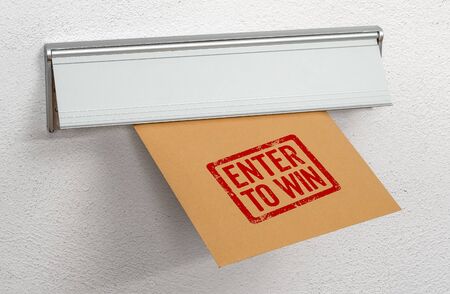 A letter stamped Enter to win in a mail slotの写真素材