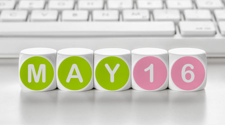 Letter dice in front of a keyboard - May 16