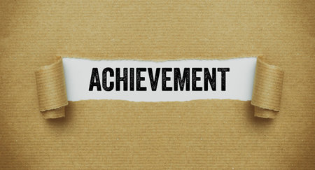 Torn paper revealing the words Achievementの写真素材