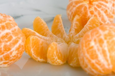 Peeled tangerines on plate isolated on whiteの写真素材