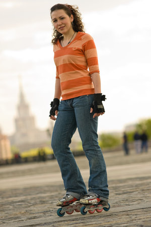 Smiling Rollerskating Girl Outdoors on Gray Background