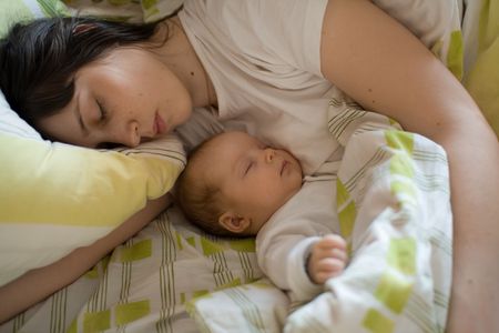 Baby with mom in the bedの写真素材