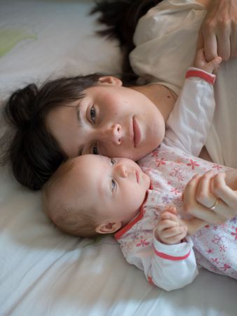 Baby with mom in the bedの写真素材