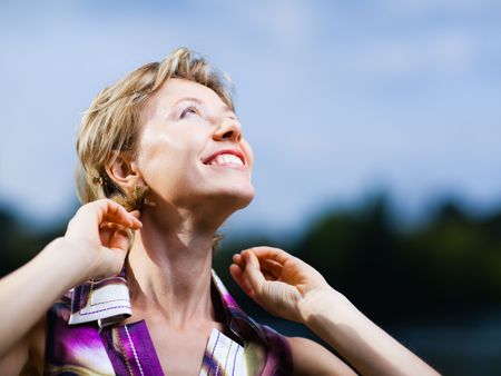 Smiling woman on a blue sky background - shallow DOFの写真素材